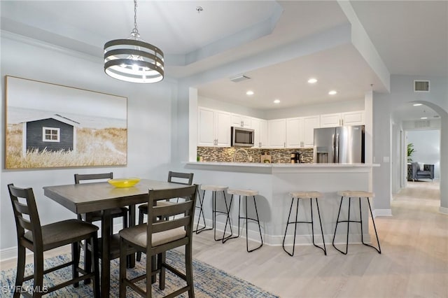 3948 Pomodoro Cir Unit 102, Cape Coral, FL 33909 - dining space with arched walkways, light wood-type flooring, a chandelier, and recessed lighting