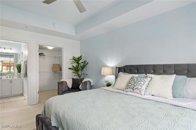 3948 Pomodoro Cir Unit 102, Cape Coral, FL 33909 - bedroom with light wood finished floors, a walk in closet, connected bathroom, a closet, and ceiling fan