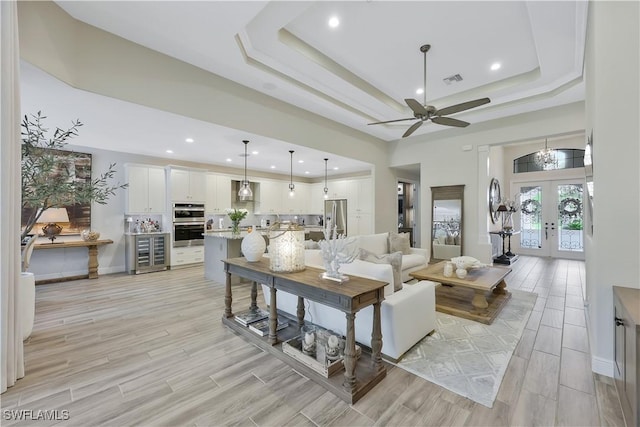10082 Palazzo Dr, Naples, FL 34119 - living room with a ceiling fan, light wood-style floors, french doors, a tray ceiling, and recessed lighting