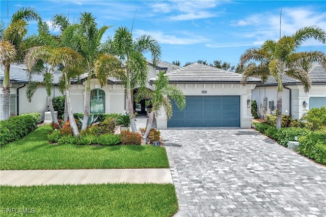 10082 Palazzo Dr, Naples, FL 34119 - ranch-style home featuring a garage, stucco siding, decorative driveway, and a front lawn