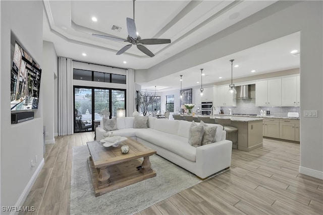 10082 Palazzo Dr, Naples, FL 34119 - living area with ceiling fan, a tray ceiling, light wood-style flooring, and recessed lighting
