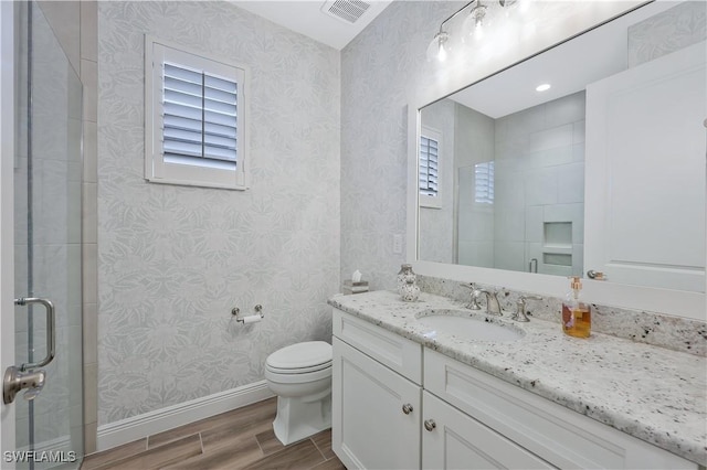 10082 Palazzo Dr, Naples, FL 34119 - bathroom with wood finished floors, vanity, plenty of natural light, wallpapered walls, and a shower with shower door