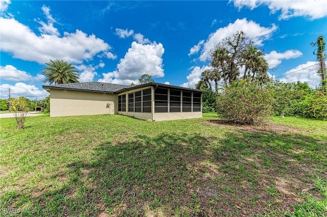 5482 Globe Ter, North Port, FL 34286 - back of house featuring a sunroom, a lawn, and stucco siding