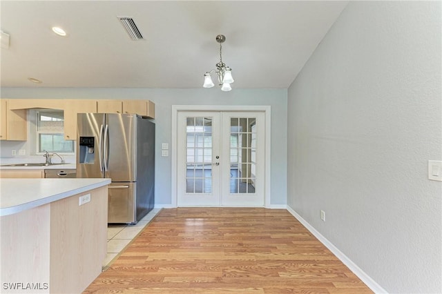 5482 Globe Ter, North Port, FL 34286 - kitchen with stainless steel fridge, light brown cabinetry, light countertops, and french doors