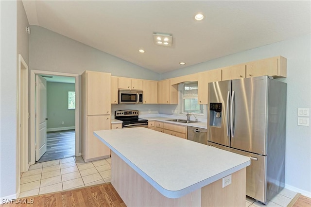 5482 Globe Ter, North Port, FL 34286 - kitchen featuring stainless steel appliances, light brown cabinetry, light countertops, vaulted ceiling, and a center island