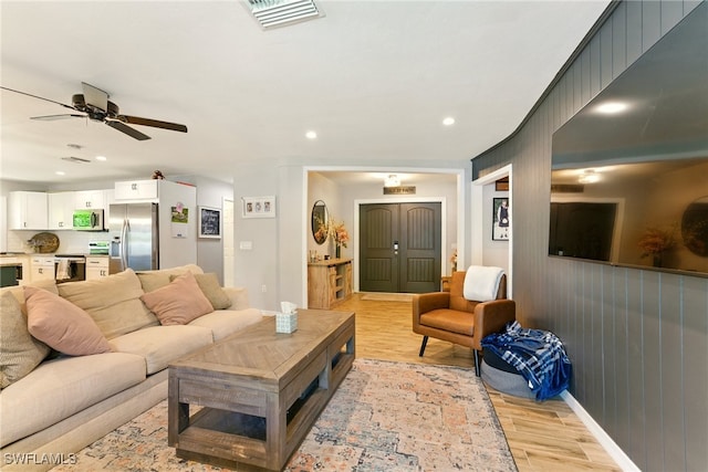 2491 43rd St SW, Naples, FL 34116 - living room with light wood finished floors, ceiling fan, recessed lighting, and wood walls