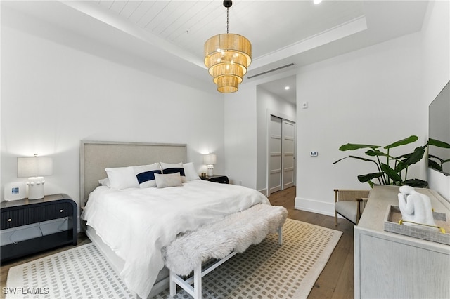 201 8th St S Unit 208, Naples, FL 34102 - bedroom with a tray ceiling, wood finished floors, a closet, recessed lighting, and a chandelier