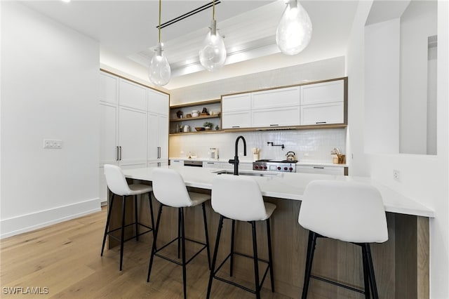 201 8th St S Unit 208, Naples, FL 34102 - kitchen featuring backsplash, light countertops, open shelves, a breakfast bar area, and white cabinets