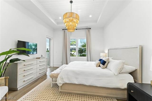 201 8th St S Unit 208, Naples, FL 34102 - bedroom with a raised ceiling, wood finished floors, a chandelier, recessed lighting, and access to outside