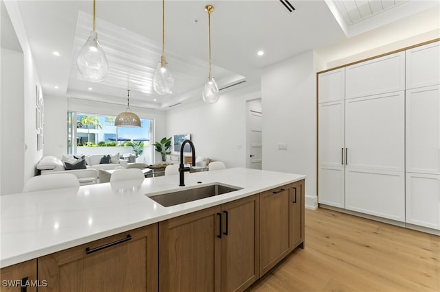 201 8th St S Unit 208, Naples, FL 34102 - kitchen featuring a tray ceiling, open floor plan, light wood finished floors, light countertops, and recessed lighting