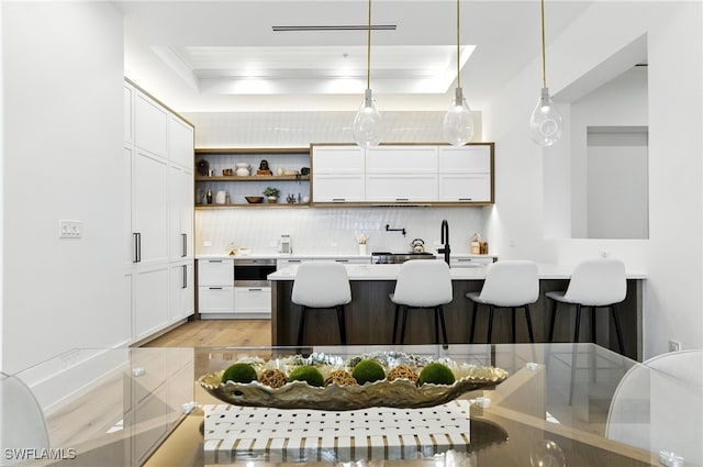 201 8th St S Unit 208, Naples, FL 34102 - kitchen with a breakfast bar, backsplash, white cabinetry, light countertops, and open shelves