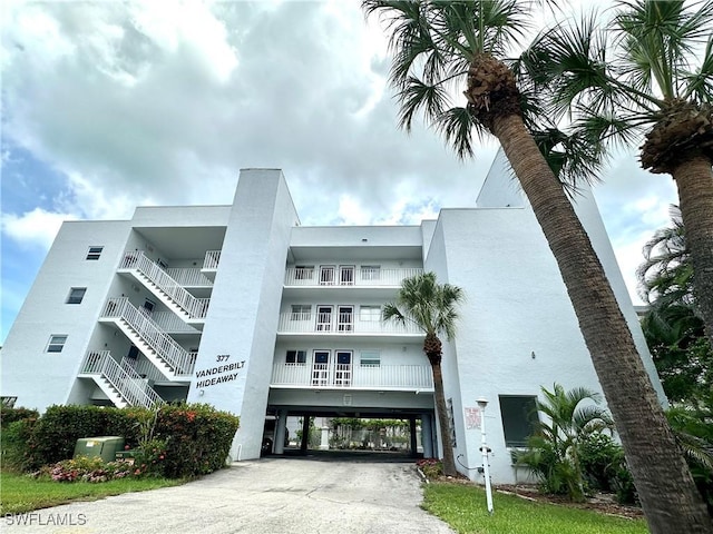377 Vanderbilt Beach Rd Unit 103, Naples, FL 34108 - view of apartment building / complex featuring a carport and driveway