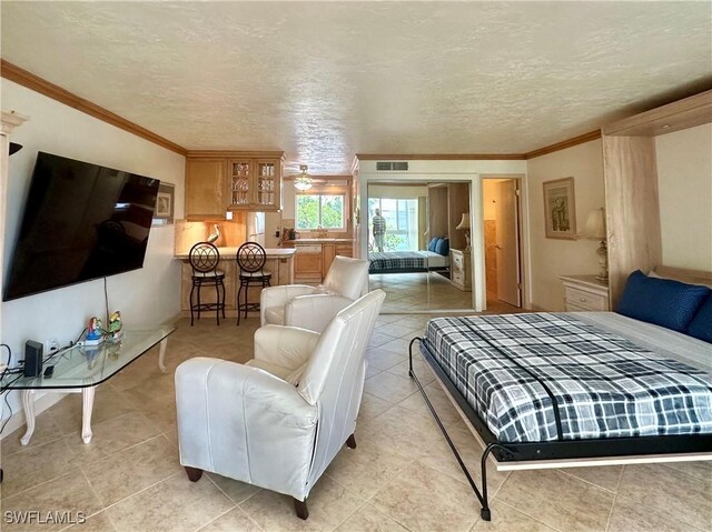 377 Vanderbilt Beach Rd Unit 103, Naples, FL 34108 - bedroom with ornamental molding, a textured ceiling, and light tile patterned floors