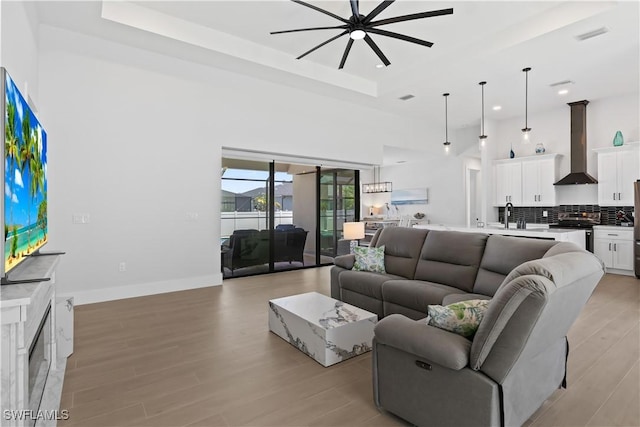 301 NW 36th Ave, Cape Coral, FL 33993 - living room with a ceiling fan, a tray ceiling, light wood-style floors, recessed lighting, and a towering ceiling