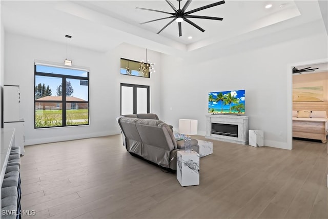301 NW 36th Ave, Cape Coral, FL 33993 - living room featuring wood finished floors, a fireplace, a raised ceiling, recessed lighting, and a chandelier