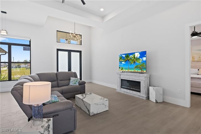 301 NW 36th Ave, Cape Coral, FL 33993 - living room with wood finished floors, a high end fireplace, a chandelier, recessed lighting, and a high ceiling
