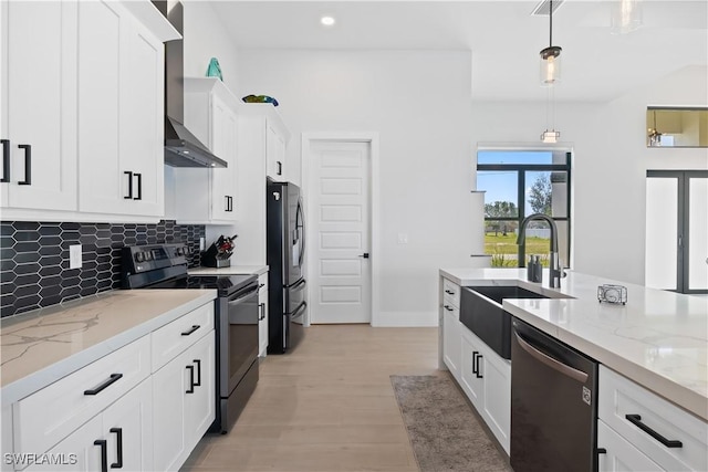 301 NW 36th Ave, Cape Coral, FL 33993 - kitchen featuring appliances with stainless steel finishes, wall chimney exhaust hood, tasteful backsplash, white cabinetry, and decorative light fixtures