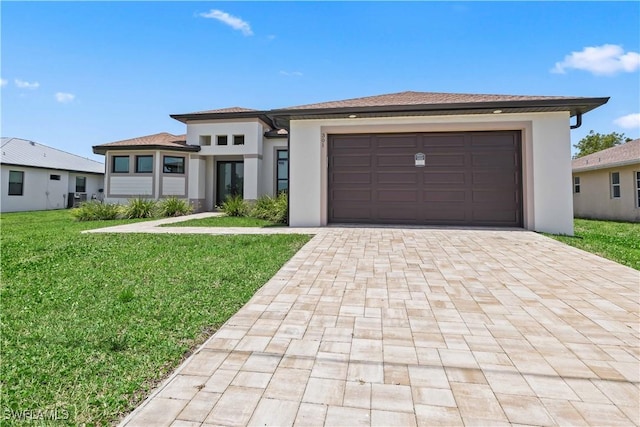 301 NW 36th Ave, Cape Coral, FL 33993 - prairie-style house featuring decorative driveway, a front yard, a garage, and stucco siding