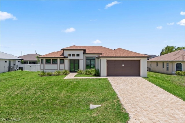 301 NW 36th Ave, Cape Coral, FL 33993 - prairie-style home with an attached garage, decorative driveway, and stucco siding