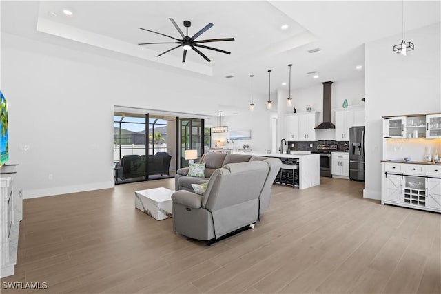 301 NW 36th Ave, Cape Coral, FL 33993 - living area featuring a raised ceiling, recessed lighting, a high ceiling, light wood-style floors, and ceiling fan