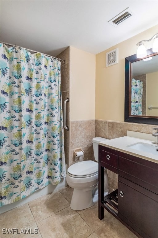 1900 Virginia Ave Unit 102, Fort Myers, FL 33901 - full bath with vanity, tile patterned flooring, tile walls, a shower with curtain, and a wainscoted wall