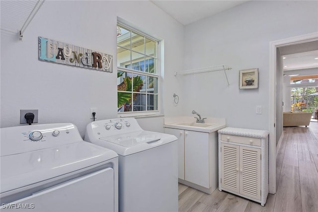 8556 Pepper Tree Way, Naples, FL 34114 - washroom featuring washing machine and dryer, cabinet space, and light wood-type flooring