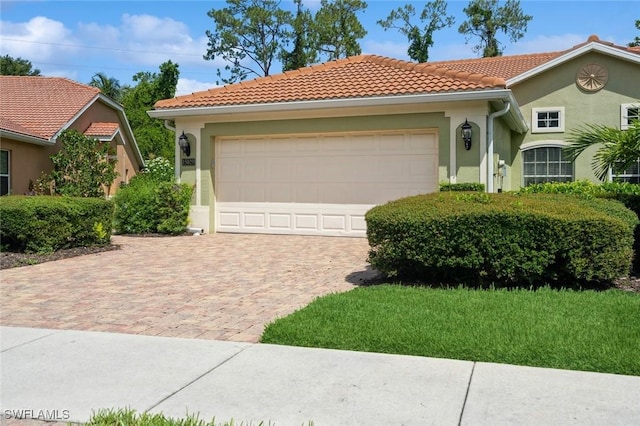 15029 Toscana Way, Naples, FL 34120 - mediterranean / spanish-style home with decorative driveway, stucco siding, a tiled roof, and an attached garage