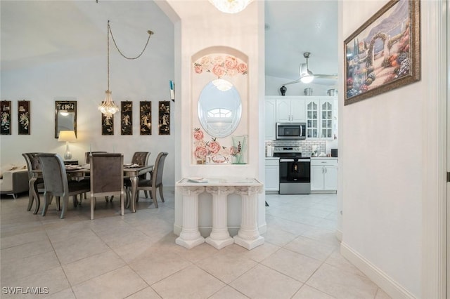 15029 Toscana Way, Naples, FL 34120 - dining space featuring light tile patterned floors, arched walkways, ceiling fan, and a high ceiling