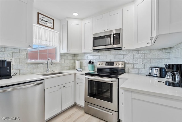 111 Bahia Via, Fort Myers Beach, FL 33931 - kitchen with stainless steel appliances, white cabinetry, light countertops, and decorative backsplash
