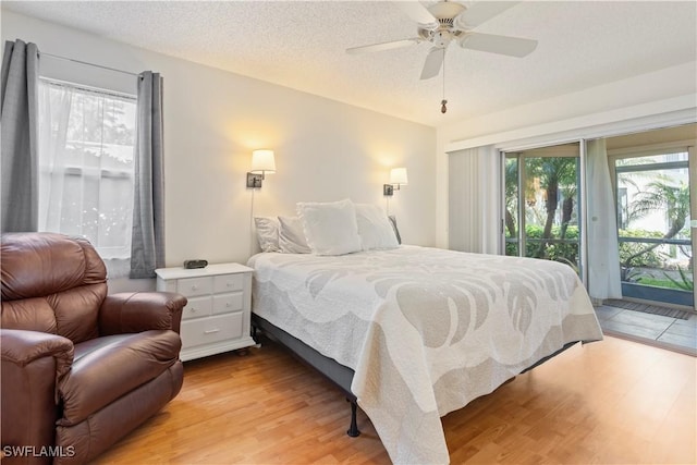 3200 Binnacle Dr Unit C1, Naples, FL 34103 - bedroom with access to exterior, light wood-type flooring, ceiling fan, and a textured ceiling