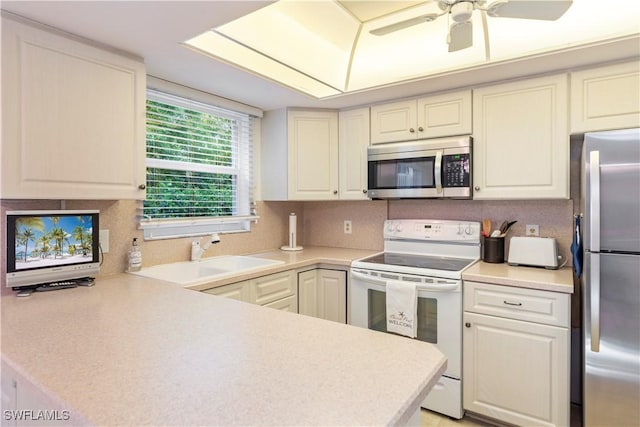 3200 Binnacle Dr Unit C1, Naples, FL 34103 - kitchen featuring appliances with stainless steel finishes, light countertops, a ceiling fan, and a peninsula