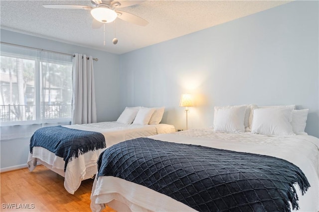 3200 Binnacle Dr Unit C1, Naples, FL 34103 - bedroom with light wood-type flooring, a textured ceiling, and a ceiling fan