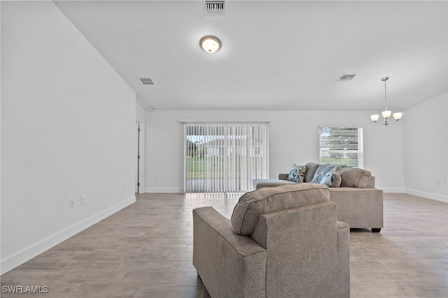 2801 50th St SW, Lehigh Acres, FL 33976 - living area featuring a chandelier, healthy amount of natural light, and vaulted ceiling