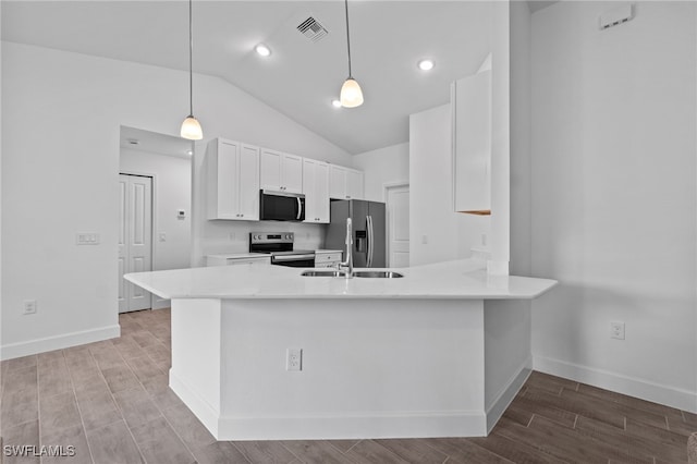 2801 50th St SW, Lehigh Acres, FL 33976 - kitchen with appliances with stainless steel finishes, lofted ceiling, white cabinets, light wood-style floors, and a peninsula