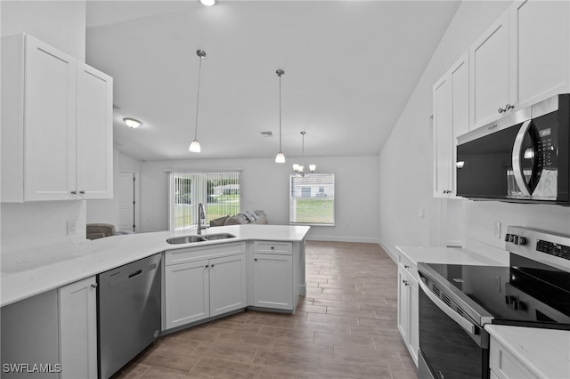 2801 50th St SW, Lehigh Acres, FL 33976 - kitchen featuring appliances with stainless steel finishes, vaulted ceiling, a peninsula, white cabinetry, and light countertops