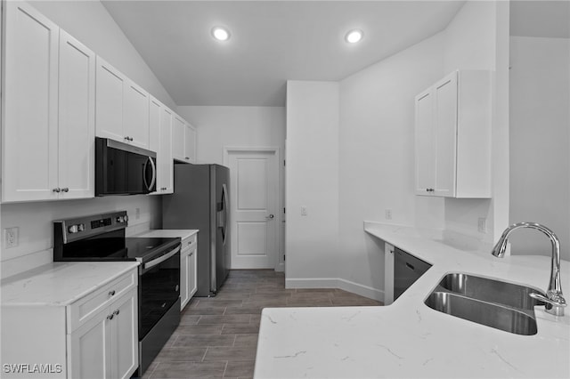 2801 50th St SW, Lehigh Acres, FL 33976 - kitchen featuring appliances with stainless steel finishes, light stone counters, white cabinetry, recessed lighting, and wood finished floors