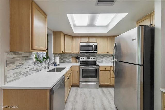 5034 Westminster Dr, Fort Myers, FL 33919 - kitchen featuring appliances with stainless steel finishes, light brown cabinets, light wood-style floors, tasteful backsplash, and light countertops