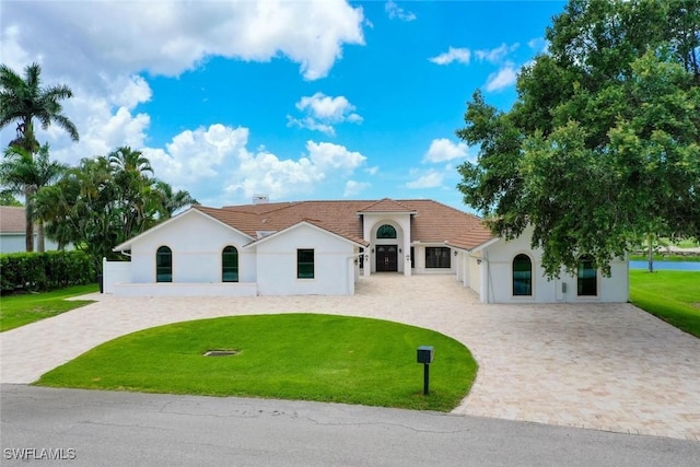 8060 Glenfinnan Cir, Fort Myers, FL 33912 - view of front of house featuring stucco siding, curved driveway, and a front yard