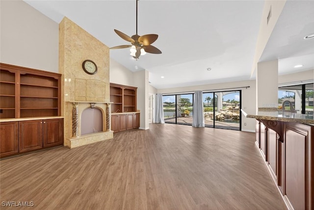 8060 Glenfinnan Cir, Fort Myers, FL 33912 - unfurnished living room with high vaulted ceiling, a fireplace, light wood-style floors, ceiling fan, and recessed lighting