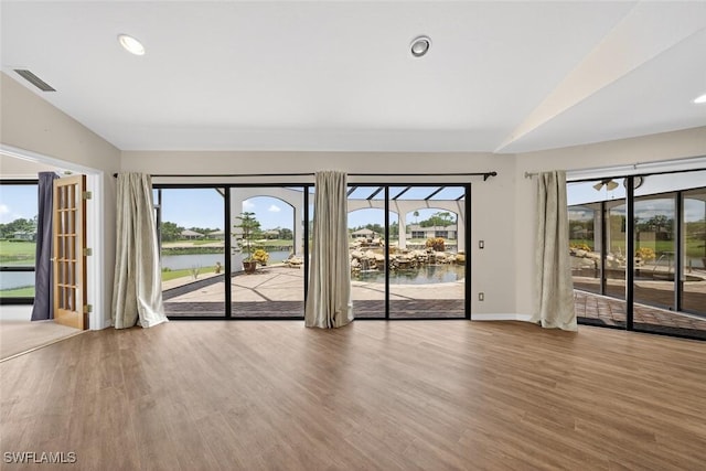 8060 Glenfinnan Cir, Fort Myers, FL 33912 - spare room featuring lofted ceiling, healthy amount of natural light, wood finished floors, a water view, and recessed lighting