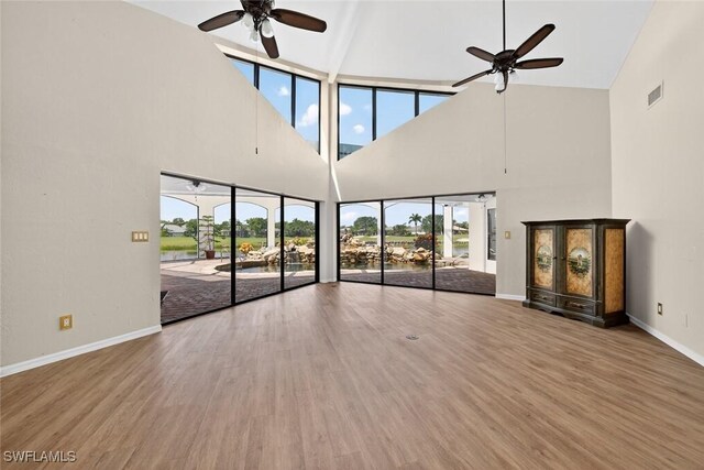 8060 Glenfinnan Cir, Fort Myers, FL 33912 - unfurnished living room featuring ceiling fan, high vaulted ceiling, healthy amount of natural light, wood finished floors, and a water view