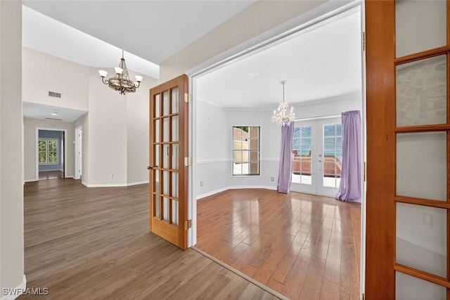 8060 Glenfinnan Cir, Fort Myers, FL 33912 - unfurnished dining area featuring french doors, a chandelier, wood finished floors, and plenty of natural light