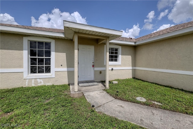 936-938 Eisenhower Blvd, Lehigh Acres, FL 33974 - view of exterior entry featuring stucco siding and a yard