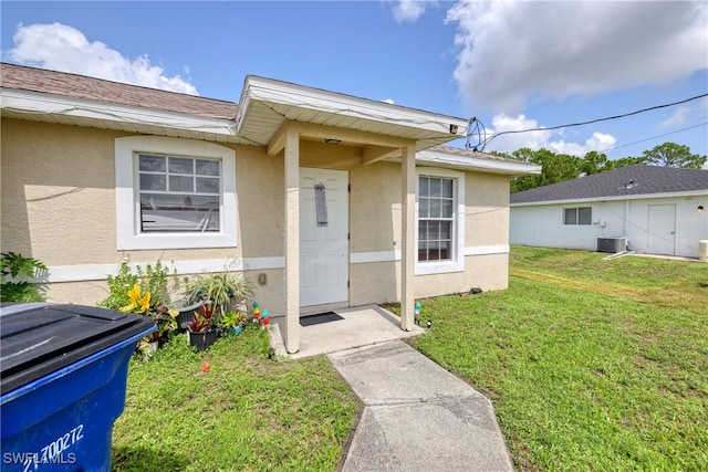 936-938 Eisenhower Blvd, Lehigh Acres, FL 33974 - view of exterior entry with stucco siding and a lawn