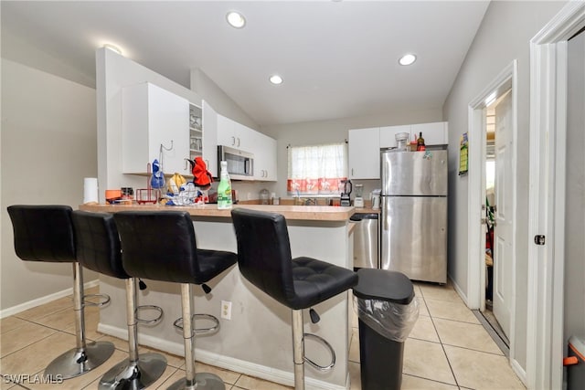936-938 Eisenhower Blvd, Lehigh Acres, FL 33974 - kitchen with stainless steel appliances, light countertops, a kitchen breakfast bar, a peninsula, and white cabinets