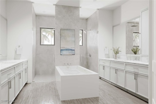 101 Beachcomber St, Marco Island, FL 34145 - bathroom featuring a garden tub, walk in shower, and two vanities