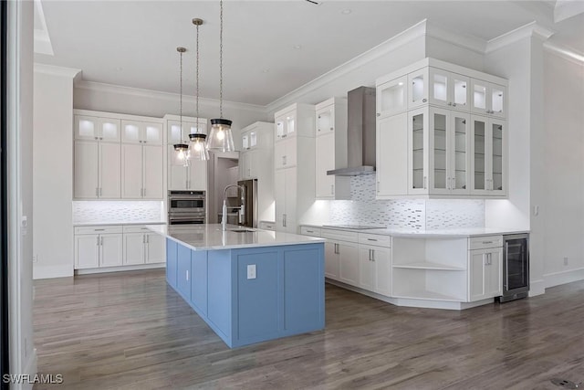 101 Beachcomber St, Marco Island, FL 34145 - kitchen featuring wall chimney range hood, beverage cooler, tasteful backsplash, a center island with sink, and crown molding