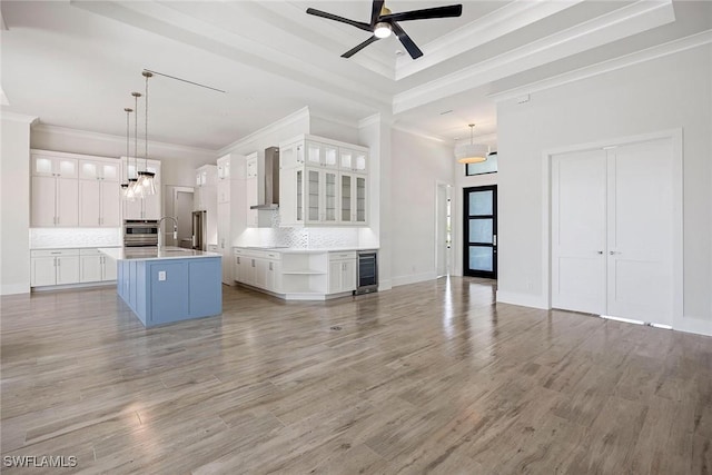 101 Beachcomber St, Marco Island, FL 34145 - kitchen featuring wine cooler, wall chimney exhaust hood, backsplash, light wood-type flooring, and ornamental molding