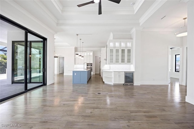 101 Beachcomber St, Marco Island, FL 34145 - unfurnished living room featuring plenty of natural light, wine cooler, ceiling fan, dark wood finished floors, and crown molding