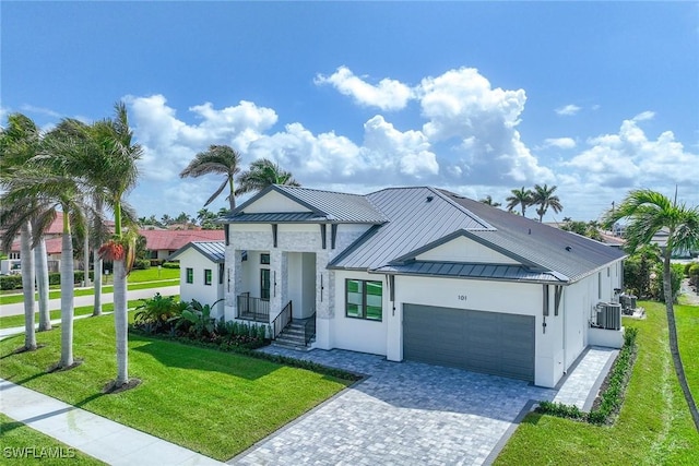 101 Beachcomber St, Marco Island, FL 34145 - view of front of home featuring stucco siding, a standing seam roof, a garage, a front lawn, and a metal roof